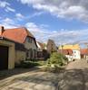 Das Foto zeigt die Straßenansicht von Rübsen mit vier verschiedenen Häuserfronten, Fußweg und Straße. Dazwischen die Front einer alten Ruine, die sich in die Ansicht einfügt.